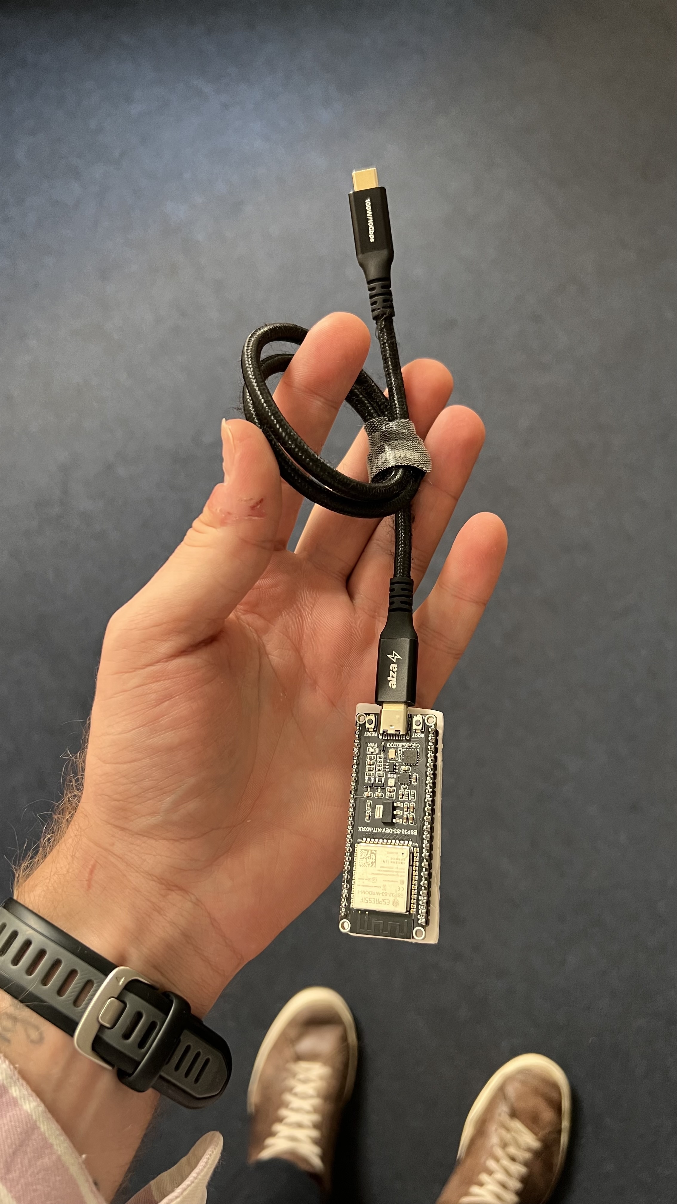 Malý USB přijímač s připojeným datovým USB-C kabelem; volný konec patří do počítače s Pro Tools.